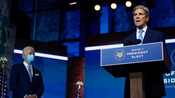 President-elect Joe Biden, left, looks on as his climate envoy nominee, former secretary of state John Kerry, speaks in Wilmington, Delaware, on November 24.